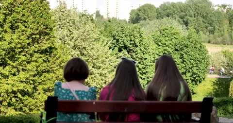 Generational Bond: Three Dark-Haired Women Admiring Blossoming Trees in a Park Видео 242224263