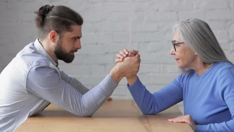 Generational confrontation. Young versus old. Armwrestling between mother and Stock Footage 203796835