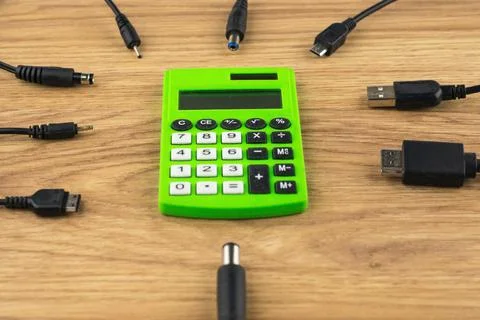 Generations of technology gap: old dusty calculator and lots of plugs and cha Stock Photos