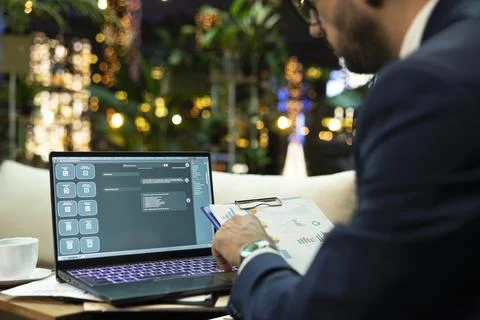 Generative AI chatbot displayed on laptop beside business executive Foto stock