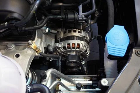 The generator (alternator) of a modern car in the engine compartment. Foto stock