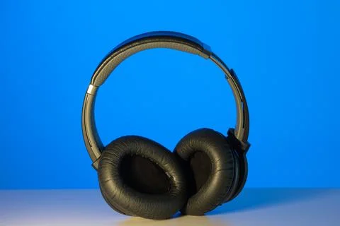 Generic black Bluetooth wireless headphone isolated on blue background 스톡 사진