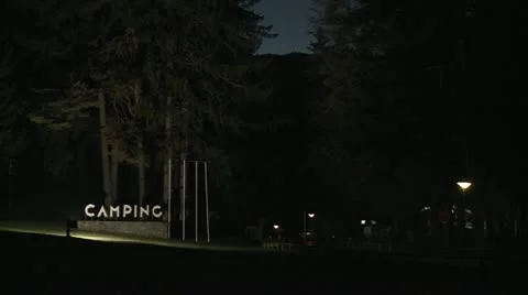 A generic campground at night with a sign that says camping. Stock Footage