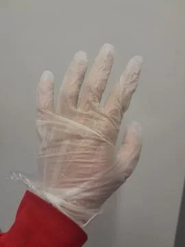 Generic disposable vinyl gloves in hand. Polyethylene gloves Photos