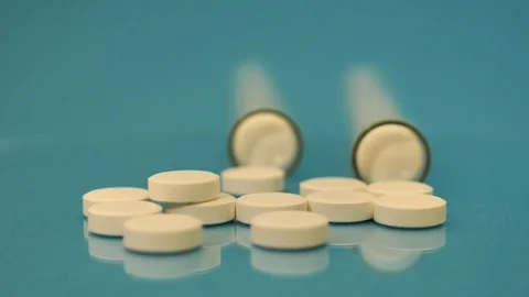 Generic drugs on table top, camera moves slowly accross spilled pills and into t Stock Footage 120248547