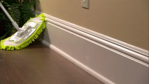 Generic floor cleaner works its ways onto baseboards Stock Footage 123849319