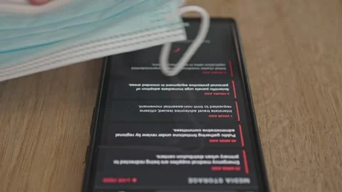 Generic mobile interface showing a pandemic warning and mandatory mask Stock Footage 337998767