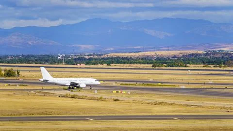 Generic plane rolling along the slope next to some high mountains, Madrid Spain. Stock Photos