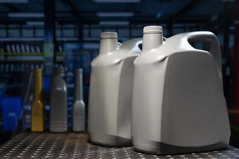 Generic plastic engine oil and chemical additive bottles on metal workbench.. 库存照片
