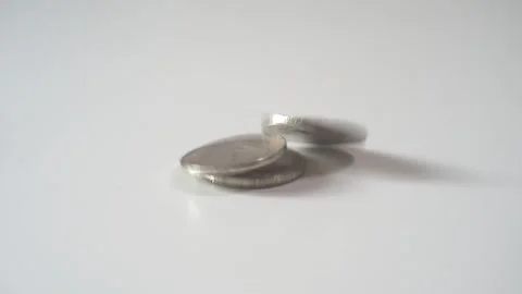 Generic silver coins falling over a white desk surface. Falling money. Stock Footage 130439391