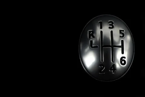Generic silver-tone six-speed car gear shift on a dark black background Stock-Fotos