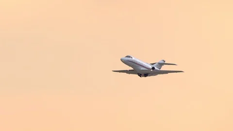 Generic Unmarked Executive Jet Taking off Into an Orange Sky Stock Footage