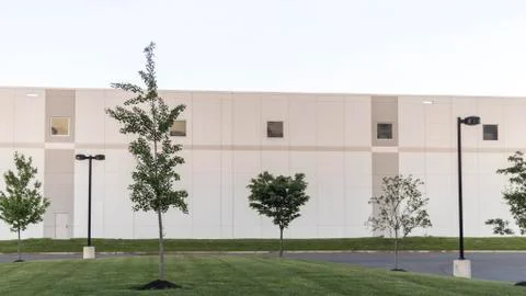 Generic Warehouse Office Complex Buildilng with Green Lawn and Streetlamps Stock Photos