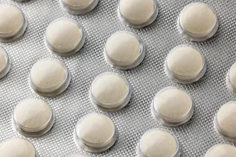 Generic white medical tablets in silver foil blister 库存照片