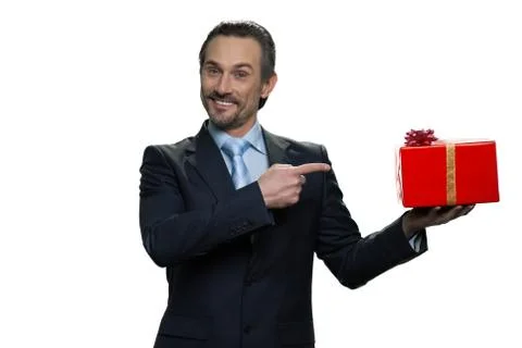 Generous formal-dressed man pointing at the gift. Stock Photos