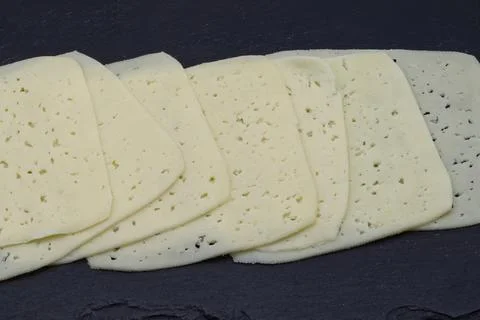 A generous stack of thin, light yellow cheese slices. Stock Photos