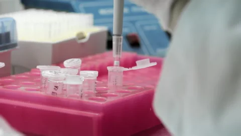 A genetics laboratory researcher drops samples with a pipette. Stock Footage 294344787