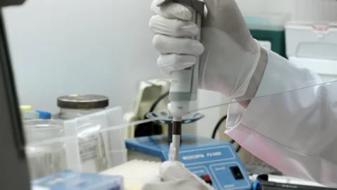 A genetics laboratory researcher drops samples with a pipette. Stock-Footage 294355052