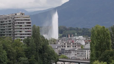 Geneva view featuring the Jet d'Eau, Alps and urban architecture on a cloudy day Stock Footage 324660584
