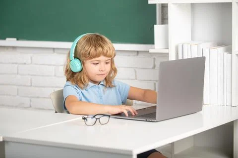 Genius child programming. Child boy in headphones using a laptop and study Foto stock