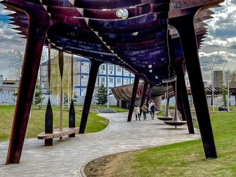 Gentle arching timber structure providing seating amidst peaceful outdoor Stock Photos
