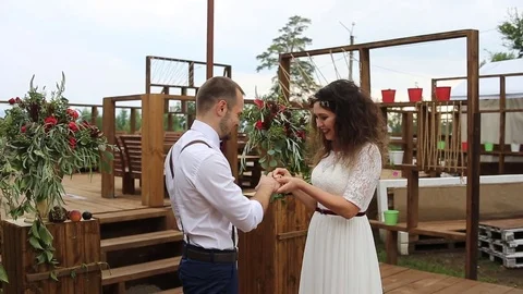Gentle beautiful bride puts wedding ring on groom's finger. Stock Footage 69888945