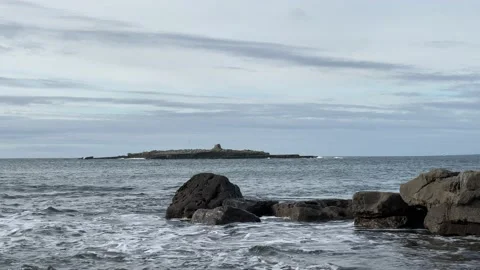 Gentle Breaking Waves With Small Rocky Island In The Background 스톡 동영상 142899747