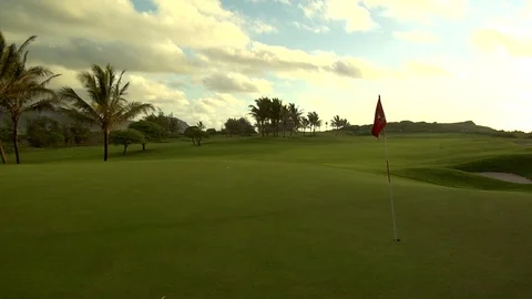 Gentle breeze blows over golf course putting green Stock Footage 125332387