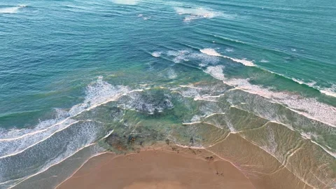 Gentle criss cross wave patterns around a sandy point Stock Footage 325276548