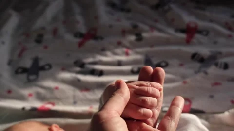 A gentle gesture as they hold the babys tiny hand in theirs Stock Footage 272184141