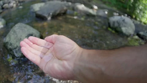 Gentle hand interacts with a serene and beautiful stream, magnificence of nature Stock Footage 285515959