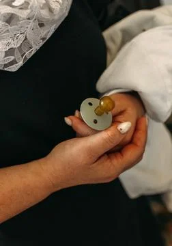 Gentle Hands Holding a Pacifier During a Christian Baptism Ceremony Stock Photos