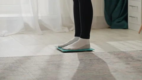 Gentle light highlights subtle scene of weight monitoring at home. Serene Stock Footage 337553020
