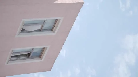 Gentle motion of clouds against pink building with windows, architectural d.. Stock Footage 332107210