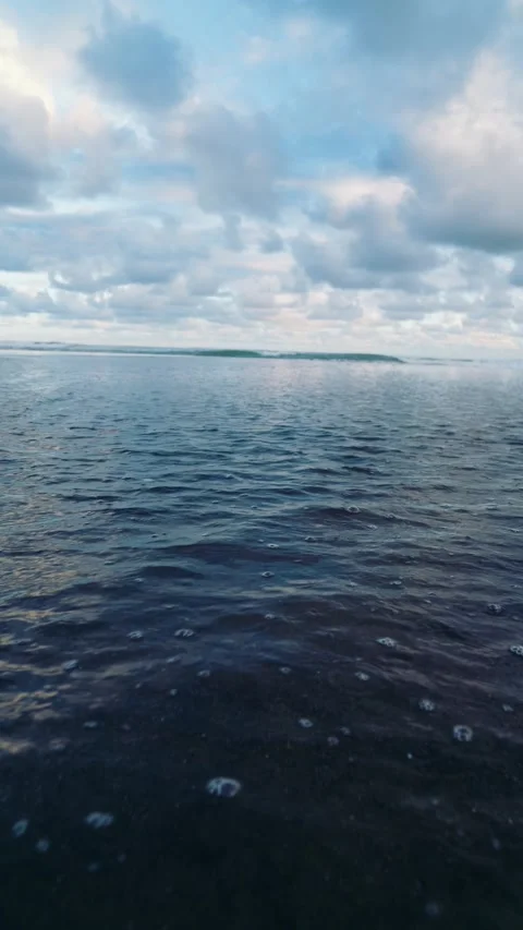 Gentle Ocean Ripples Beneath Dramatic Cloudy Tropical Sky Stock Footage 337979065