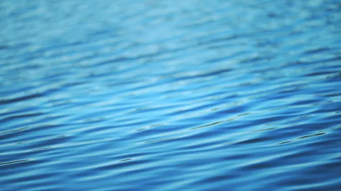 Gentle ocean water ripples creating a serene blue abstract background in 4K slow Stock Footage 326057416