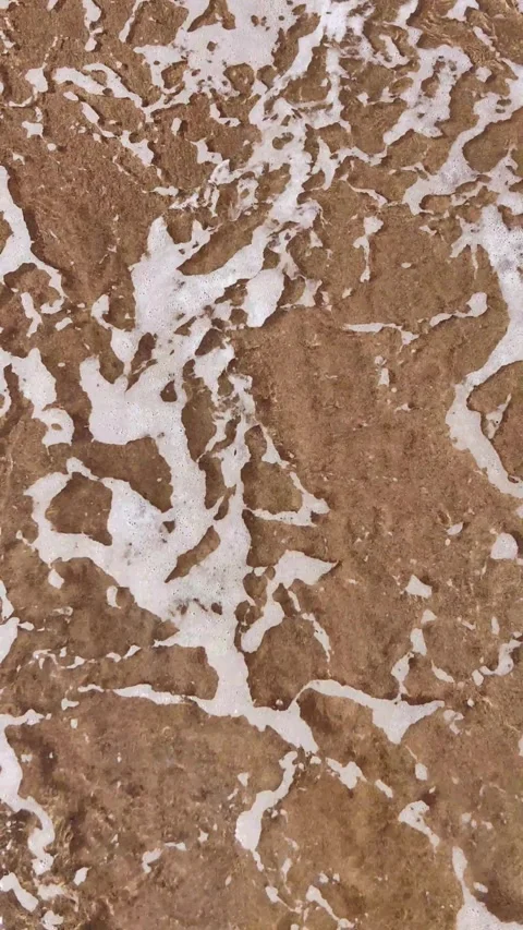 Gentle ocean wave washing over sandy beach. vertical. Видео 335765728
