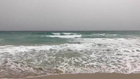 Gentle Ocean Waves Breaking Onto Sand on a Cloudy Day Stock Footage 106356041