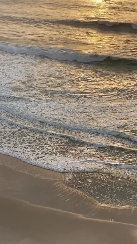 Gentle ocean waves breaking on the shore in golden light. Stock Footage 314844970