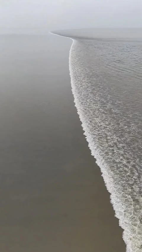 Gentle Ocean Waves Breaking on a Tranquil, Misty Beach on an Overcast Day, China Stock Footage 337380740
