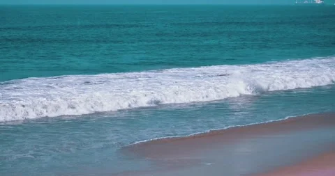 Gentle ocean waves rolling onto a sandy beach Stock Footage 339519937