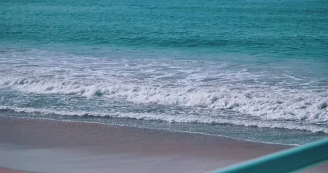 Gentle ocean waves rolling onto sandy beach Stock Footage 339519970