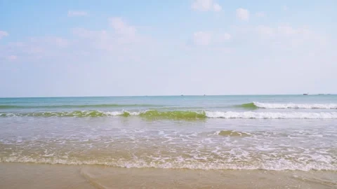 Gentle Ocean Waves Rolling Onto A Sandy Beach Under A Clear Blue Sky Stock Footage 342225542