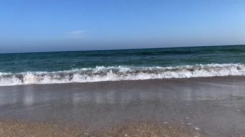 Gentle Ocean Waves on Sandy Beach Under Clear Blue Sky Stock Footage 331937785