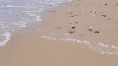 Gentle ocean waves washing over sandy beach with pebbles 動画素材 346520271