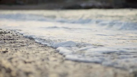 Gentle Ocean Waves Washing Sandy Beach at Sunset 4K Stock Footage 336464954