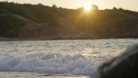 Gentle Ocean Waves Washing Sandy Beach at Sunset 4K Stock Footage 336465354