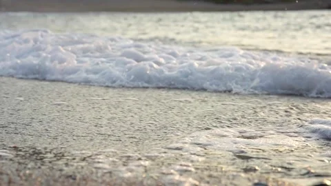 Gentle Ocean Waves Washing Sandy Beach at Sunset 4K Stock Footage 336465358