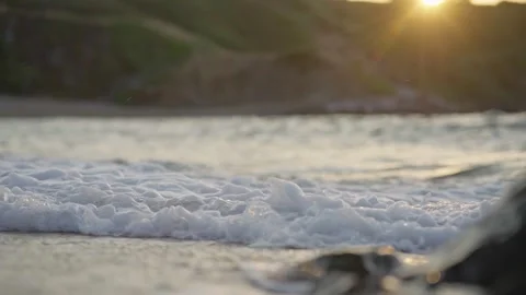 Gentle Ocean Waves Washing Sandy Beach at Sunset 4K Stock Footage 336465375
