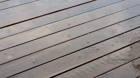 Gentle Rain on Weathered Deck Creating Serene Ripples Stock Footage 342225240